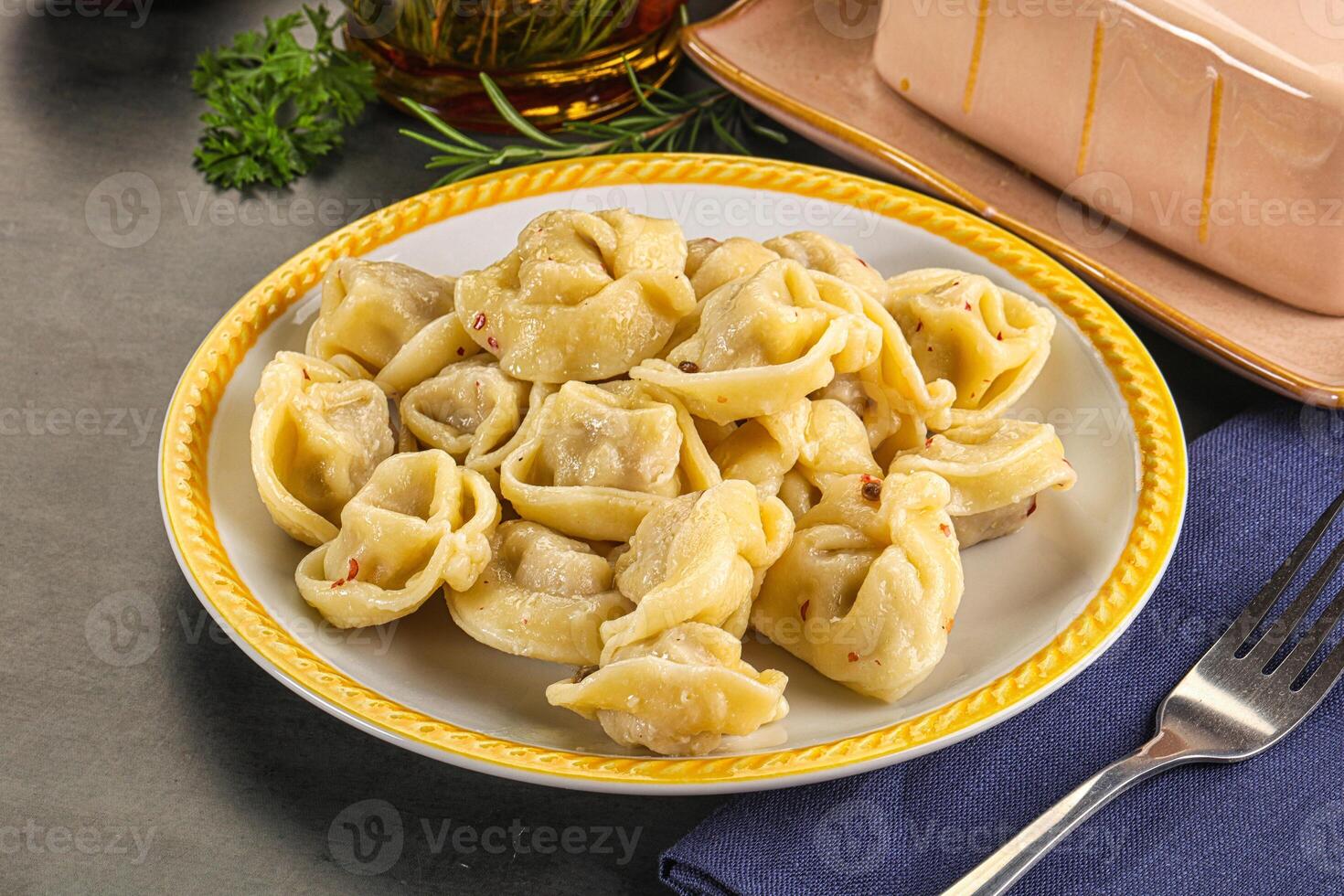 A plate of pasta with a fork and knife on a table photo