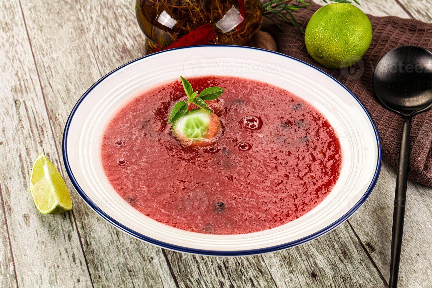 A bowl of soup with a lime and a spoon photo