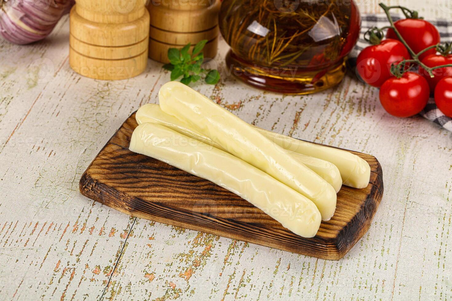 A wooden cutting board with cheese sticks on it photo