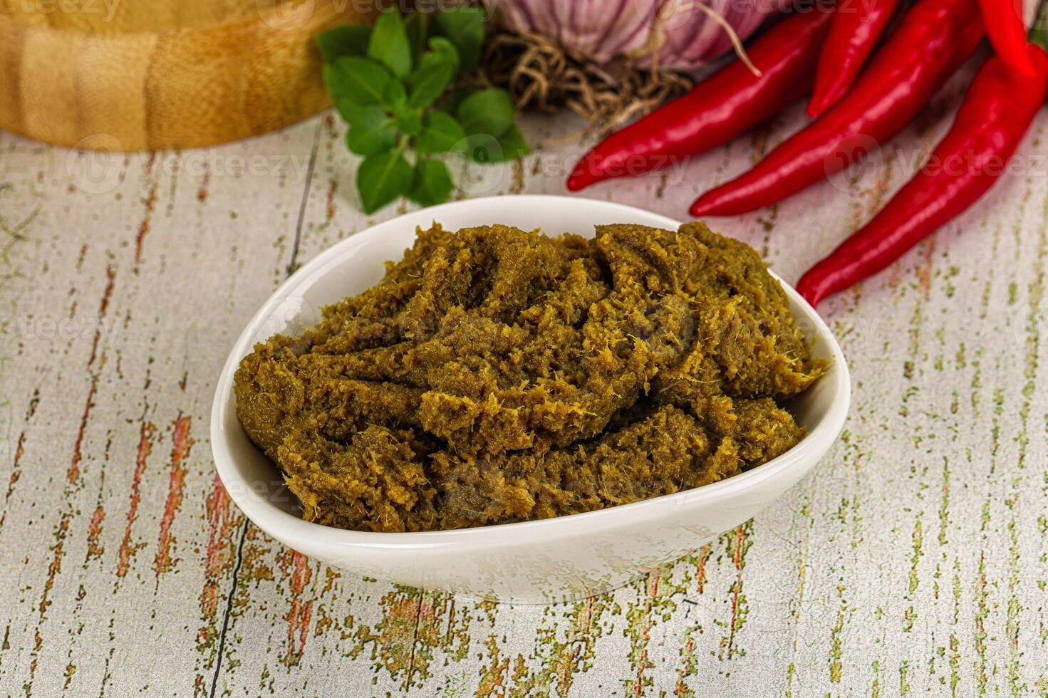 A bowl of green curry paste with red peppers and garlic photo