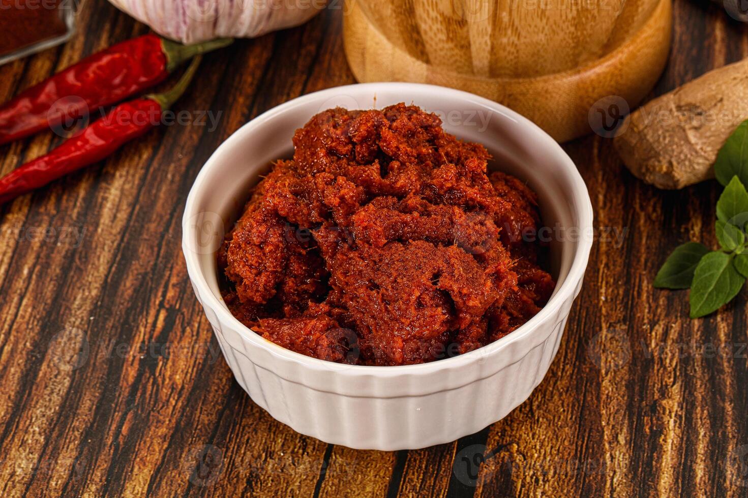 A bowl of chili powder on a wooden table photo