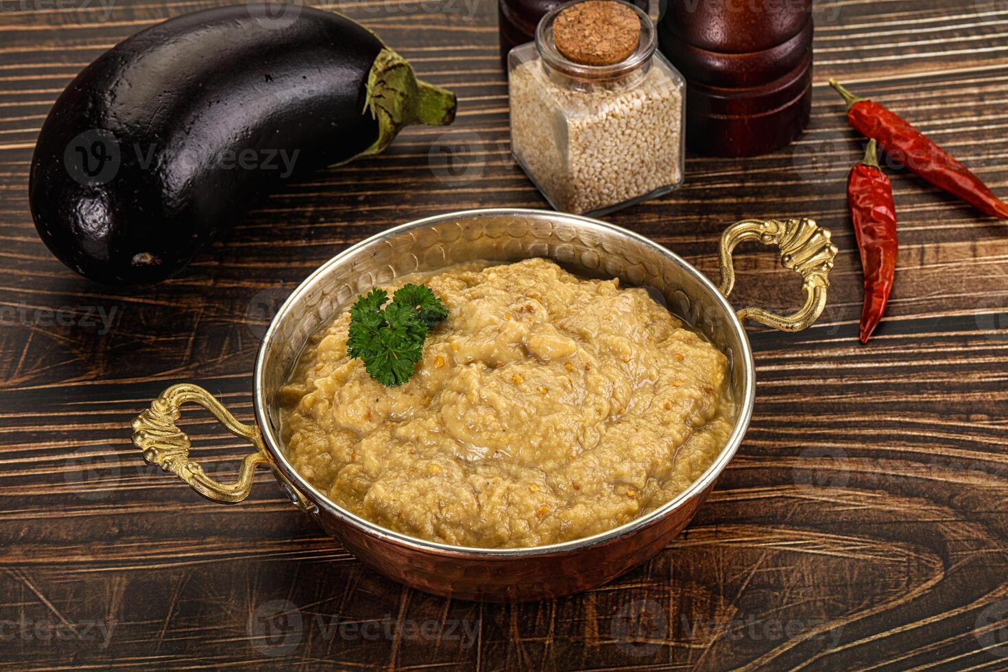 A bowl of food on a table next to a bottle of spices photo