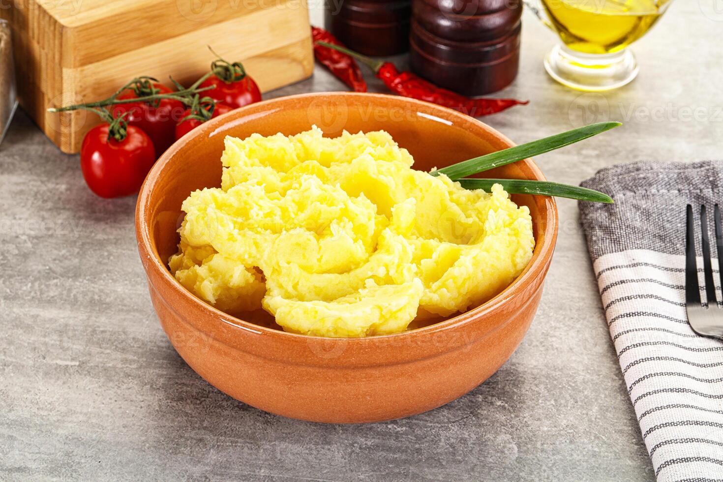 A bowl of mashed potatoes with a green leaf on top photo