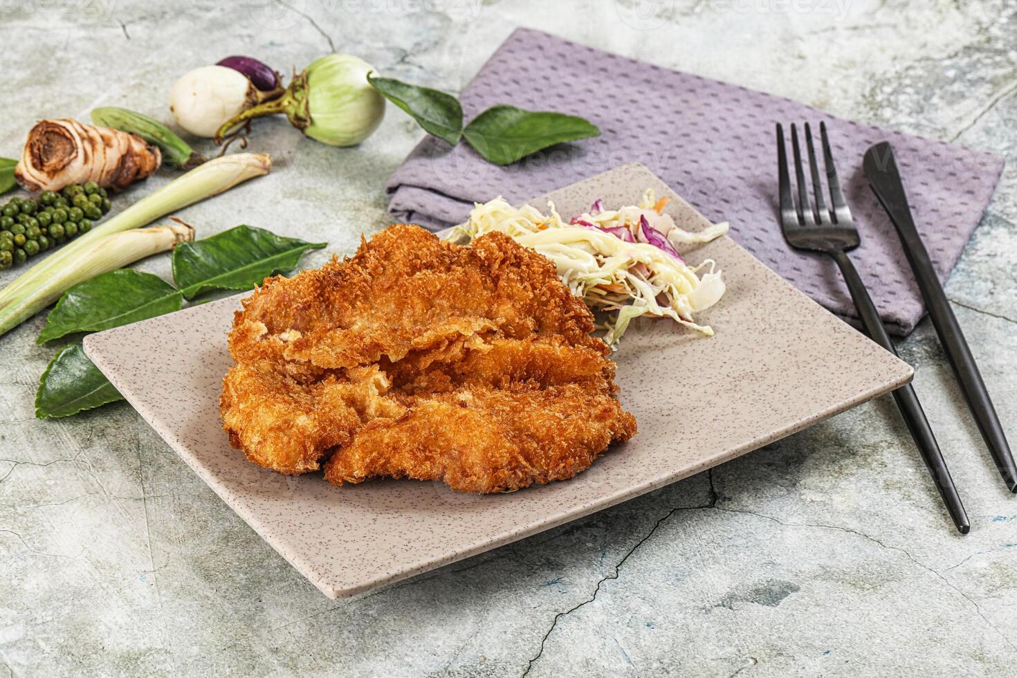 Fried chicken on a plate with vegetables and a napkin photo