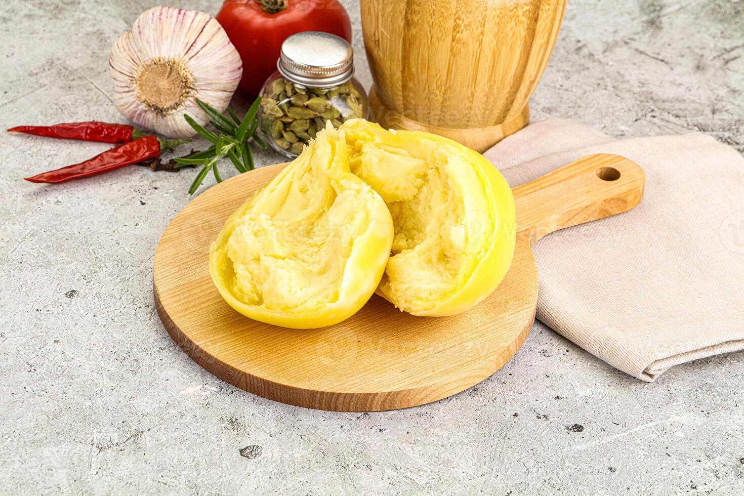 A wooden cutting board with a pepper and a knife photo