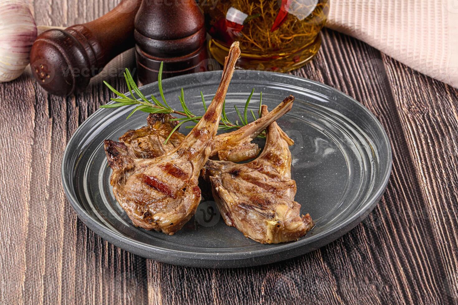 Grilled lamb chops on a plate with herbs and garlic photo