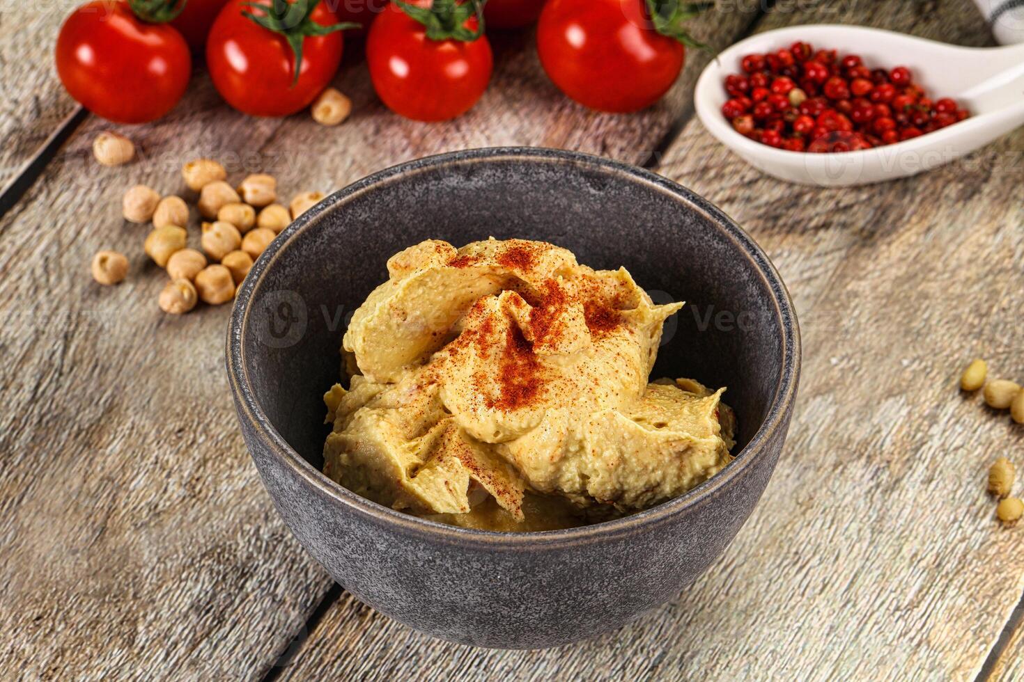 A bowl of hummus with tomatoes and peppers photo