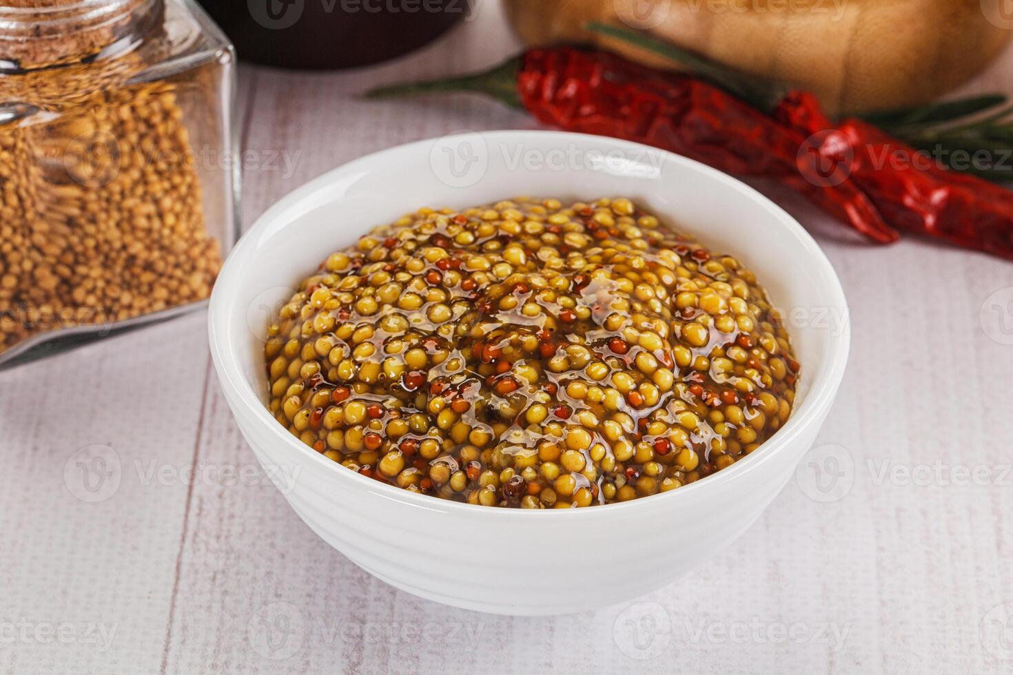 A bowl of mustard and spices on a table photo