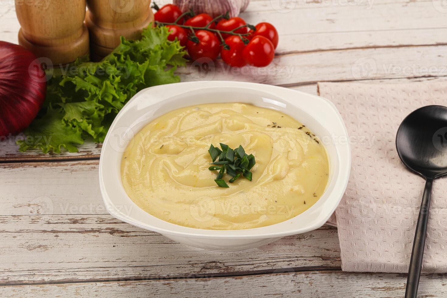 A bowl of soup with a spoon and some vegetables photo