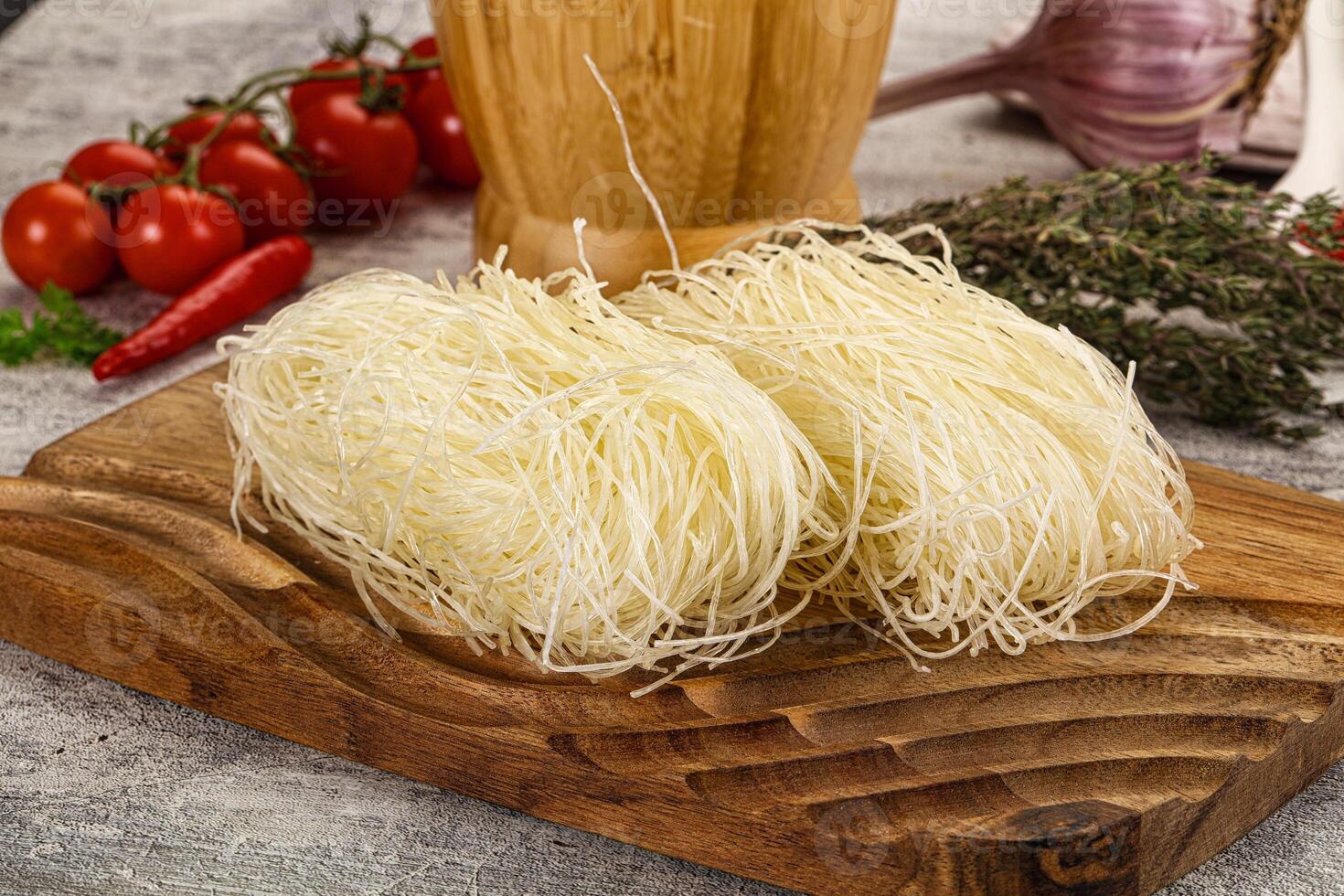 A wooden cutting board with two pieces of noodles photo
