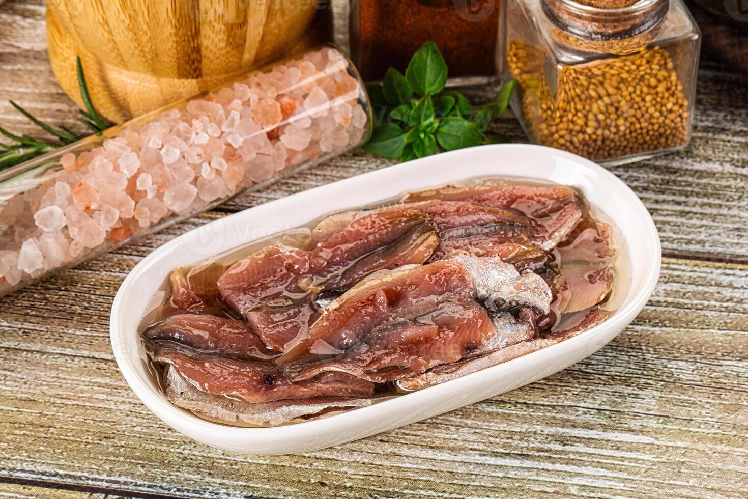 A bowl of meat and spices on a wooden table photo