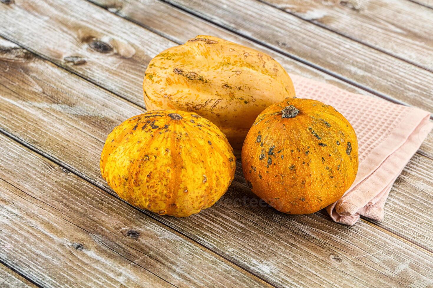 Three pumpkins on a wooden table photo