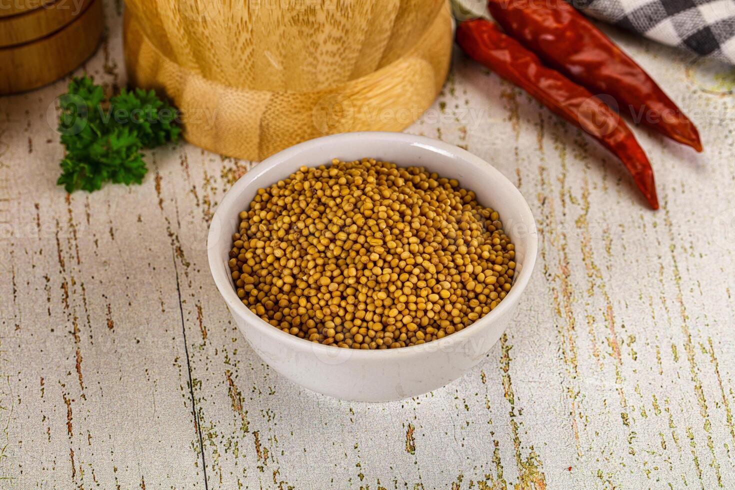 Dried mustard seeds in a bowl on a wooden table photo