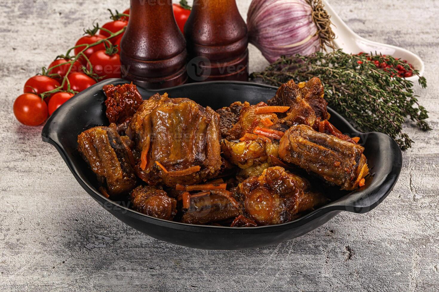 A bowl of meat with vegetables and tomatoes photo