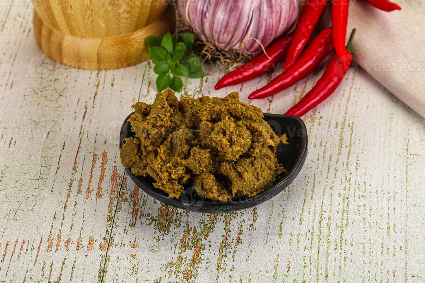 A bowl of spices and a pepper on a wooden table photo