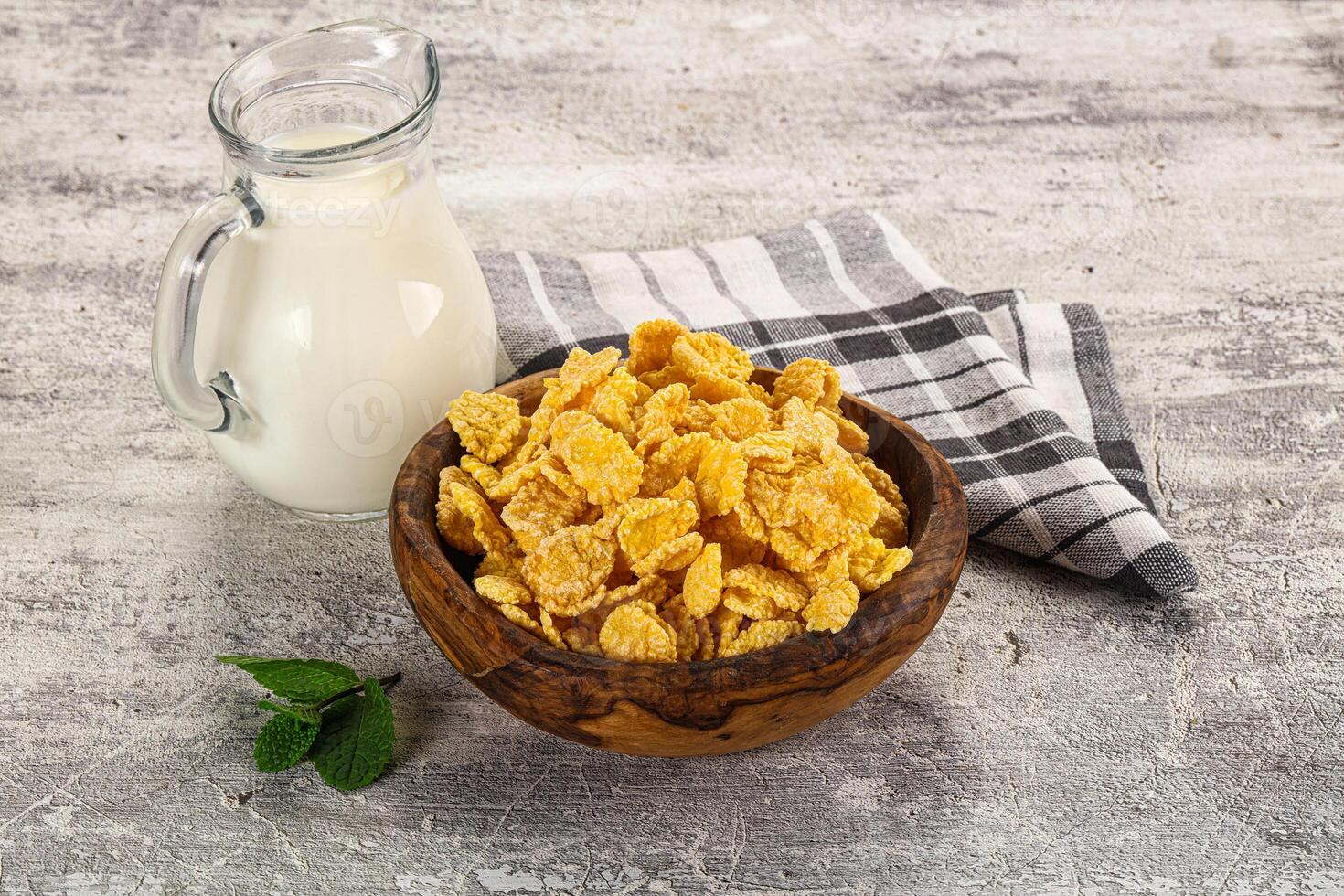 Corn flakes and milk on a wooden table photo