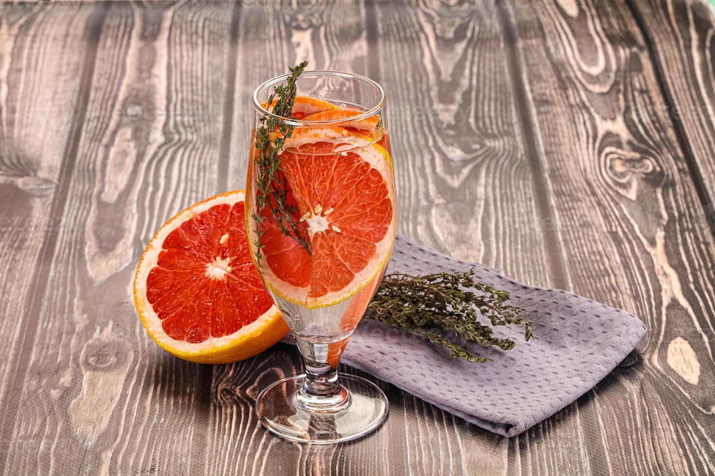 A glass of orange juice and a grapefruit on a table photo