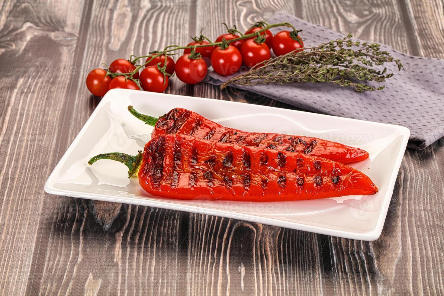 Grilled peppers on a white plate with herbs photo