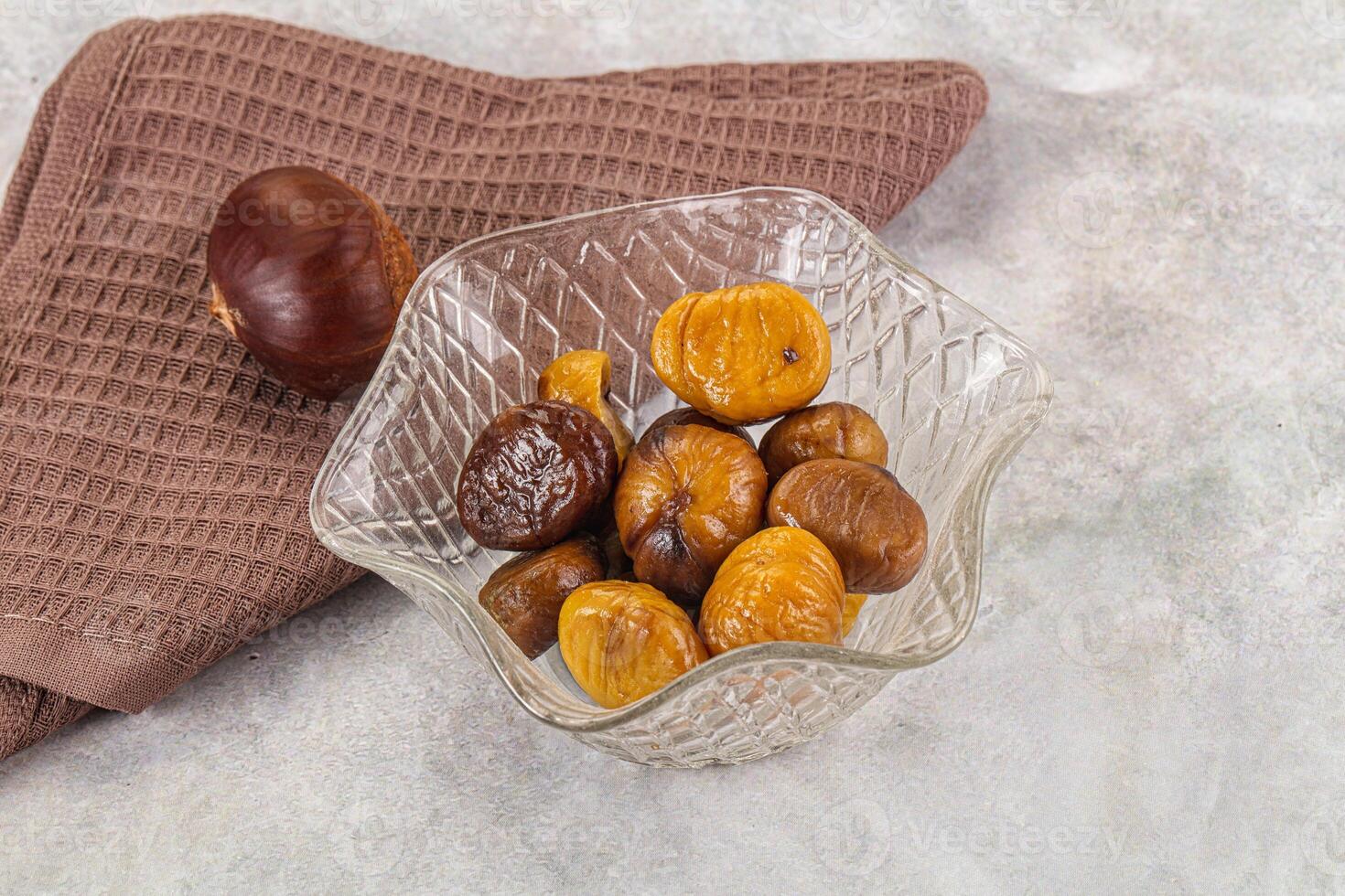 A bowl of dried fruit and a towel on a table photo