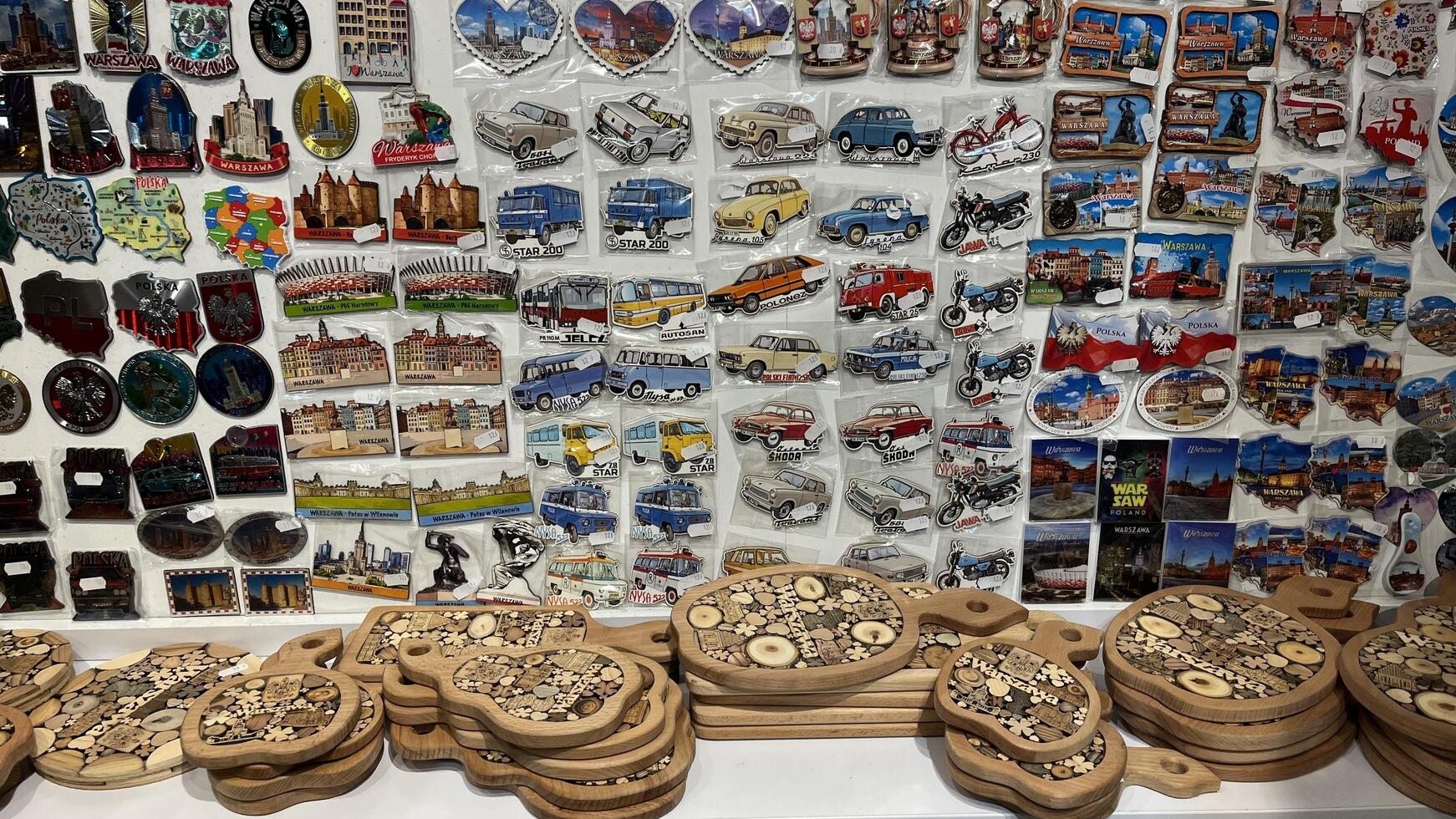Warsaw, Poland. November 01, 2024. A display of various souvenirs, primarily fridge magnets and wooden cutting boards. The magnets depict iconic landmarks, vehicles, and cityscapes photo