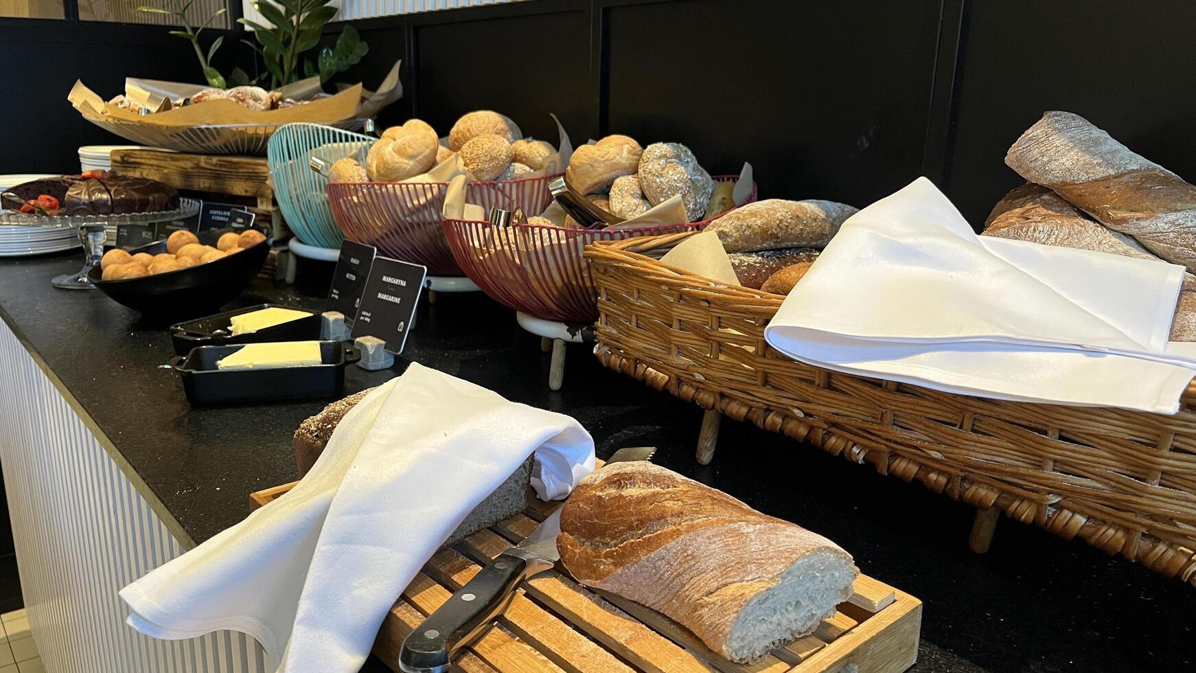 Warsaw, Poland. November 02, 2024. Fresh baked breads and pastries are displayed on a buffet table. There are different types of bread, including rolls, baguettes, and loaves photo