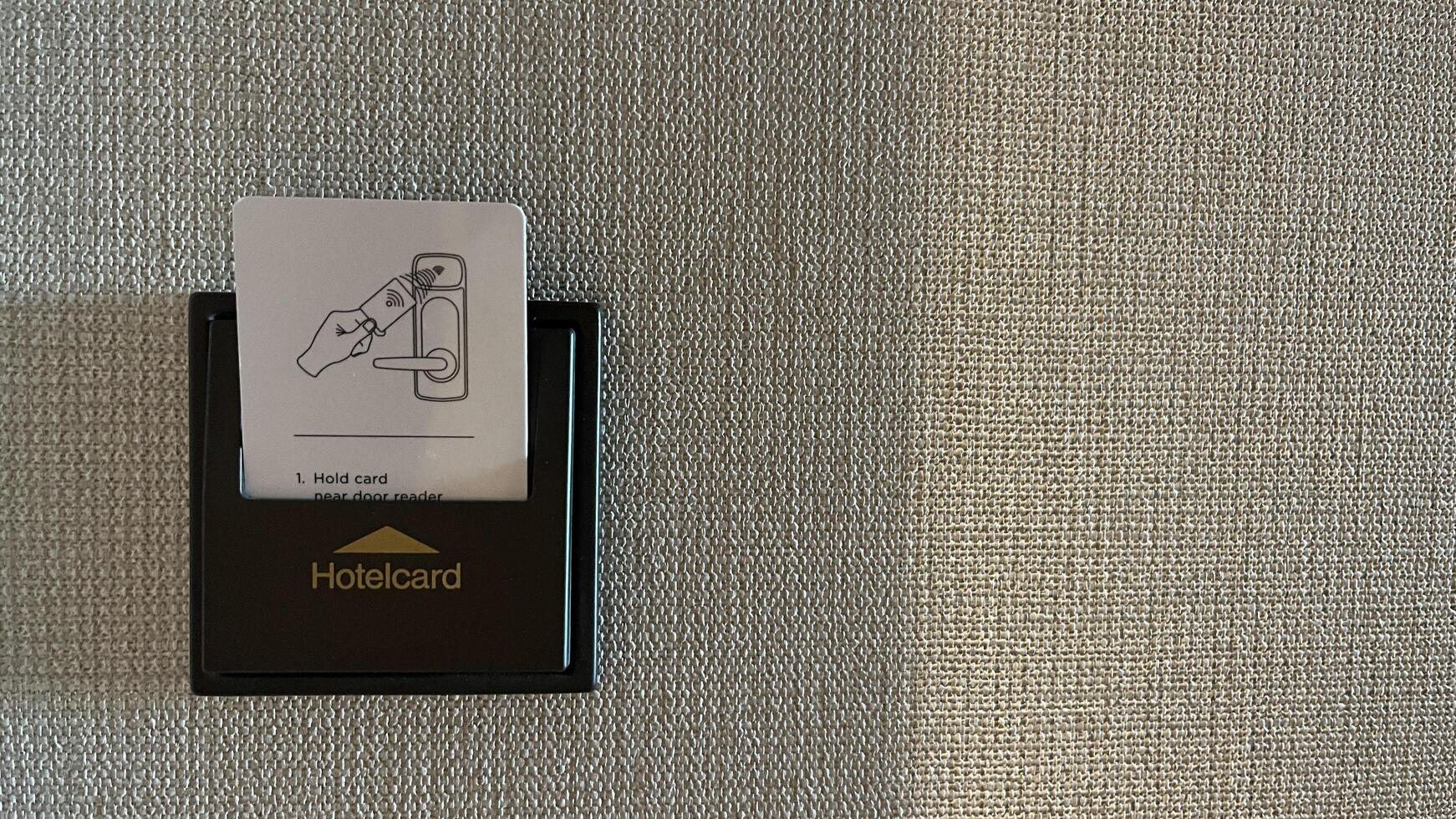 Warsaw, Poland. November 02, 2024. A close-up of a hotel room with a keycard reader. The reader has a small instruction card showing how to use the keycard to unlock the door photo
