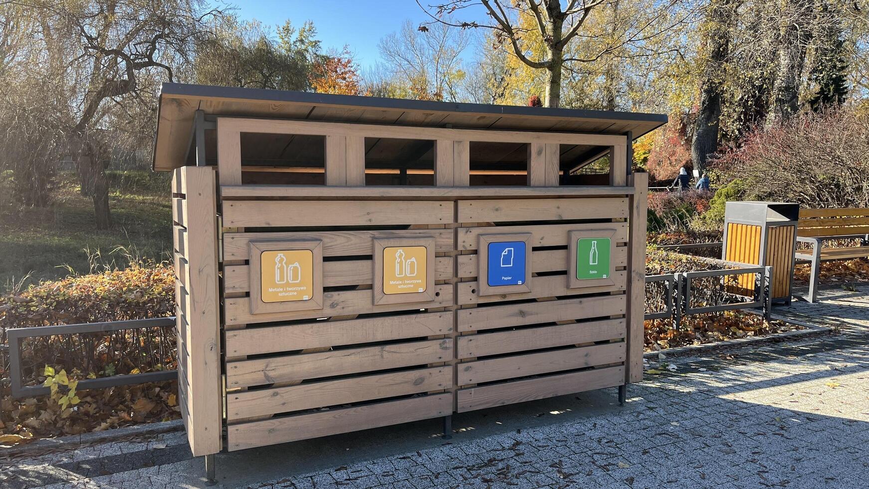 Warsaw, Poland. November 02, 2024. A wooden recycling bin with four compartments for different types of waste. Each compartment has a symbol indicating the type of waste. photo