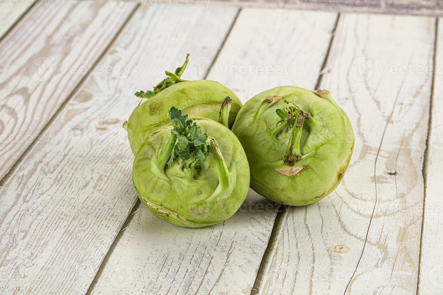 Three green vegetables sitting on a wooden table photo