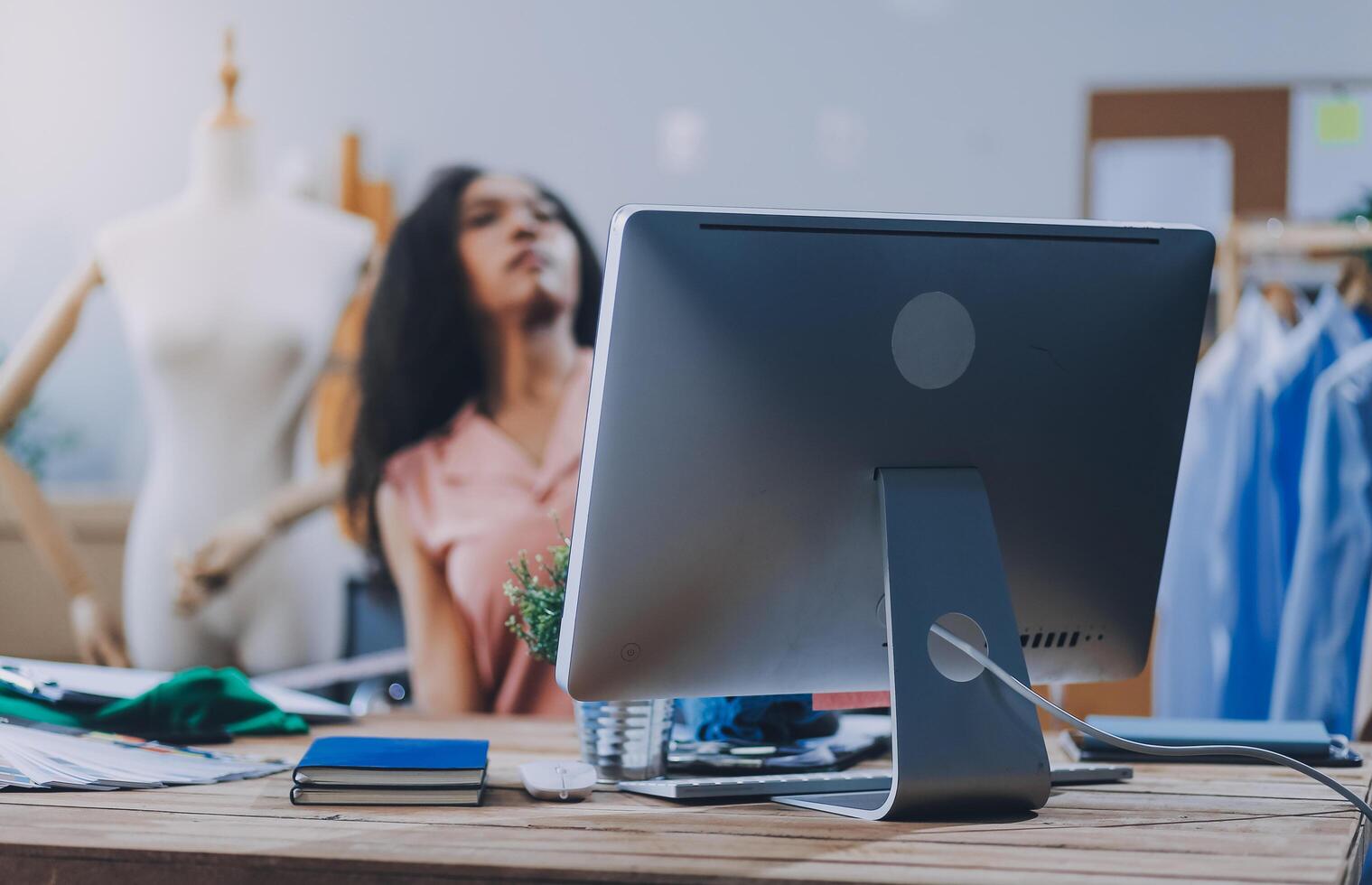 A woman is sitting at a desk with a computer photo