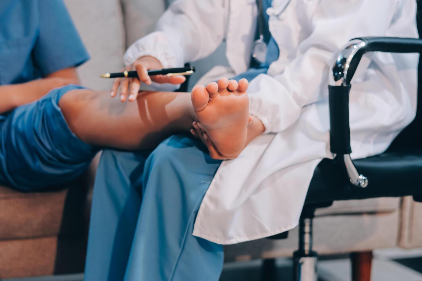 A doctor is holding a pen to a woman's foot photo