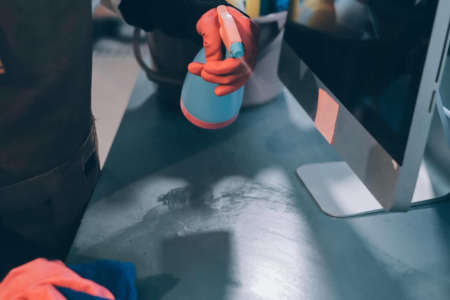 A person cleaning a computer monitor with a sponge photo