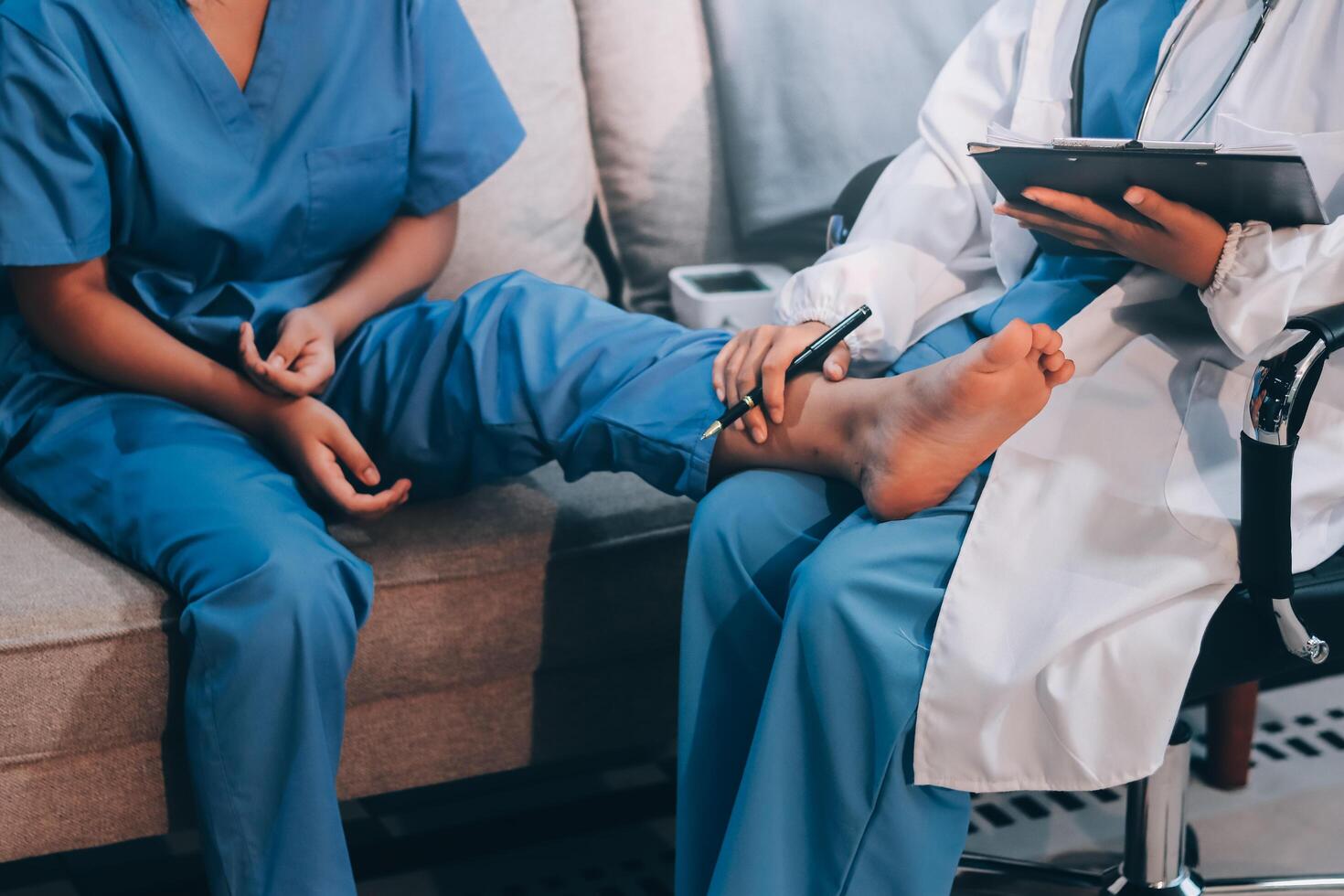 A doctor is holding a clipboard while a nurse is sitting on a couch photo