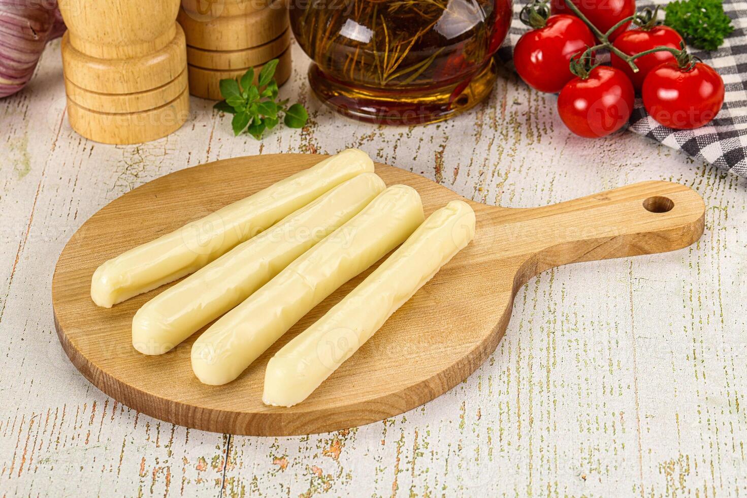 A wooden cutting board with several pieces of cheese on it photo