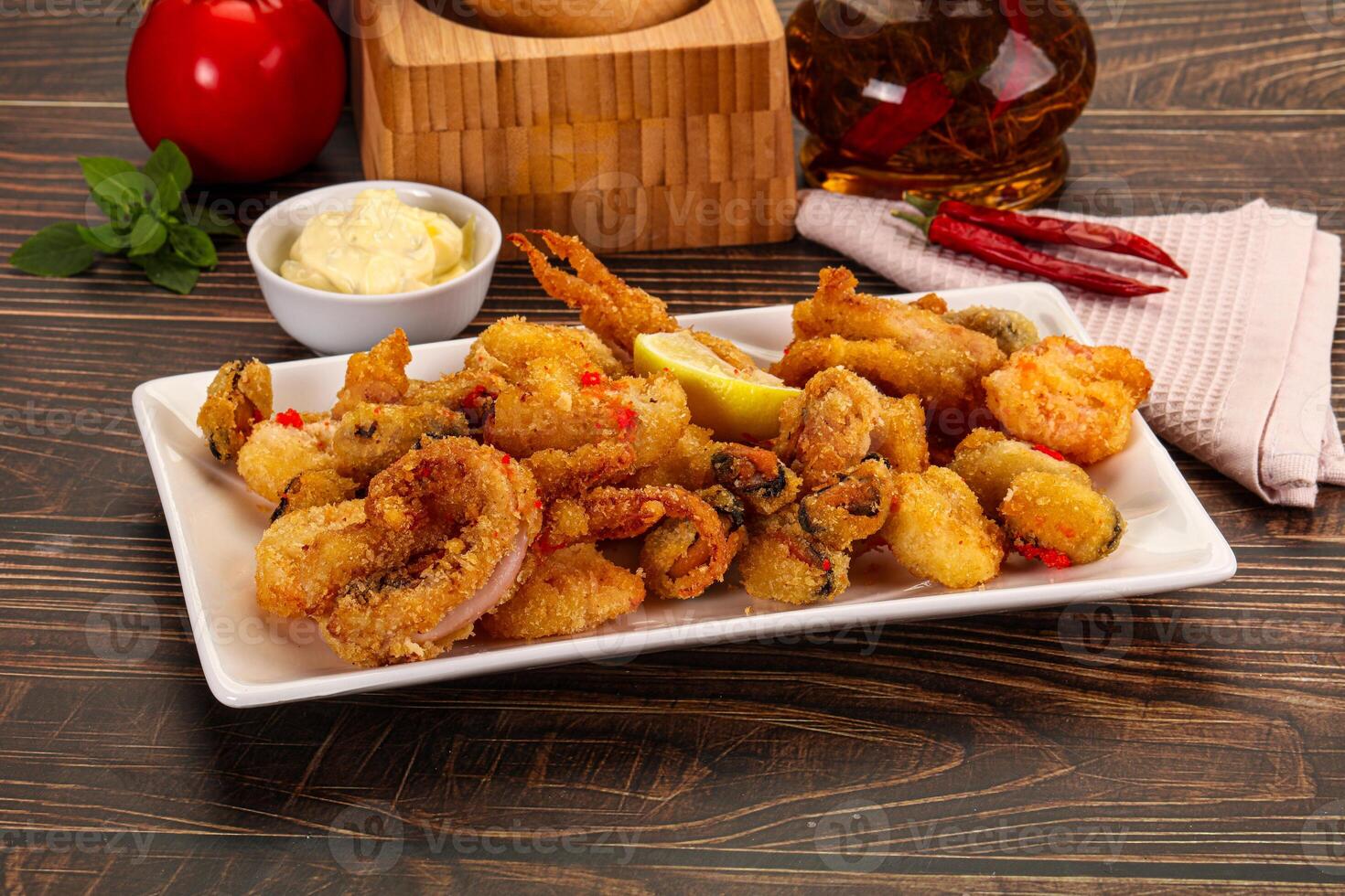 A plate of fried shrimp and other food on a table photo