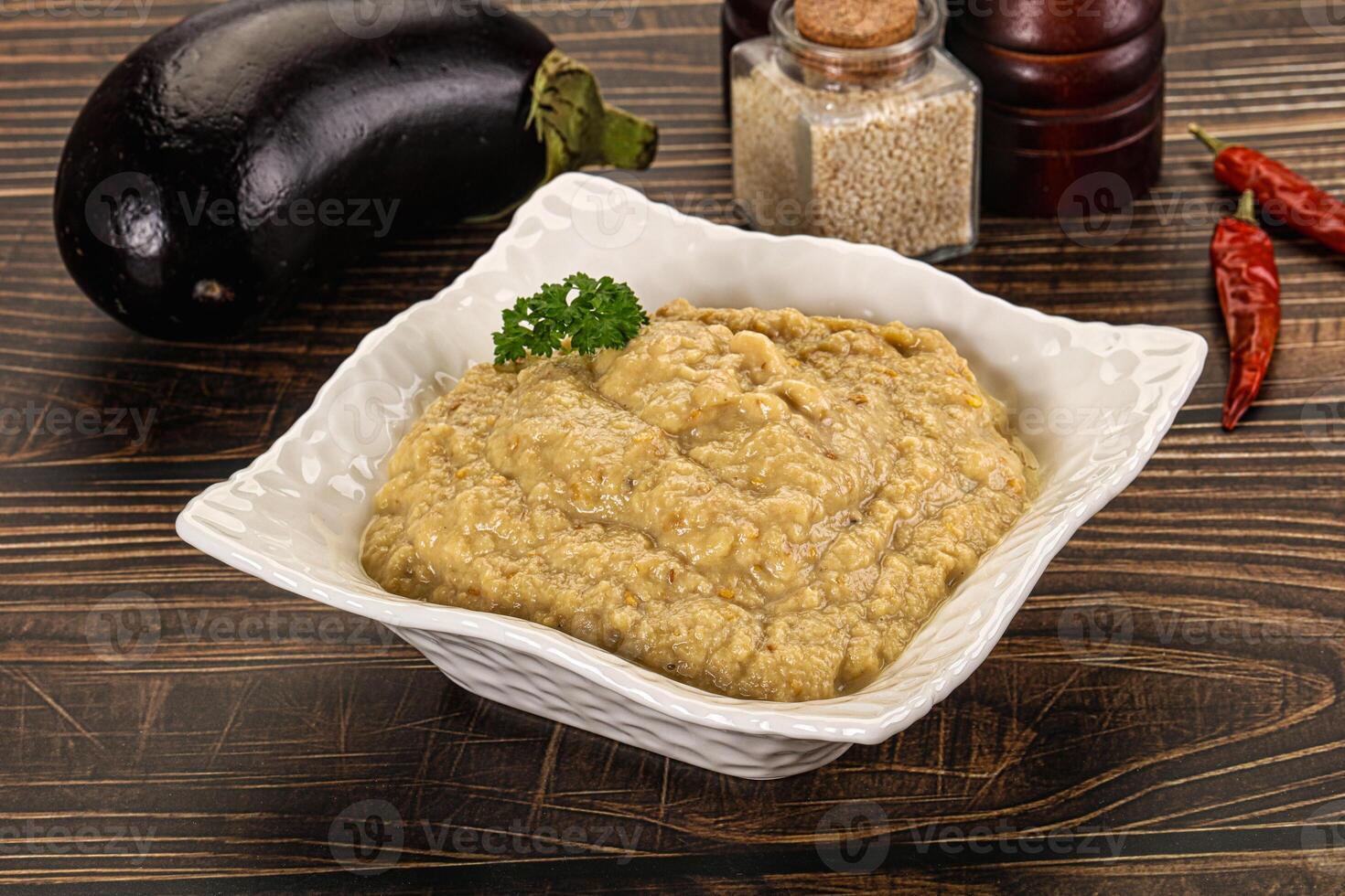 A bowl of eggplant dip with spices and vegetables photo