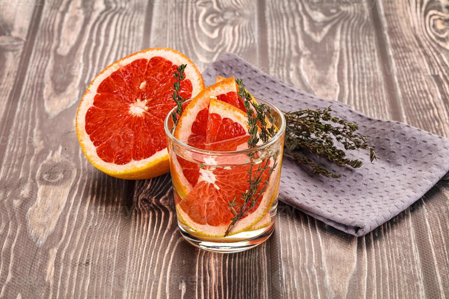 A glass of orange juice and a grapefruit on a table photo