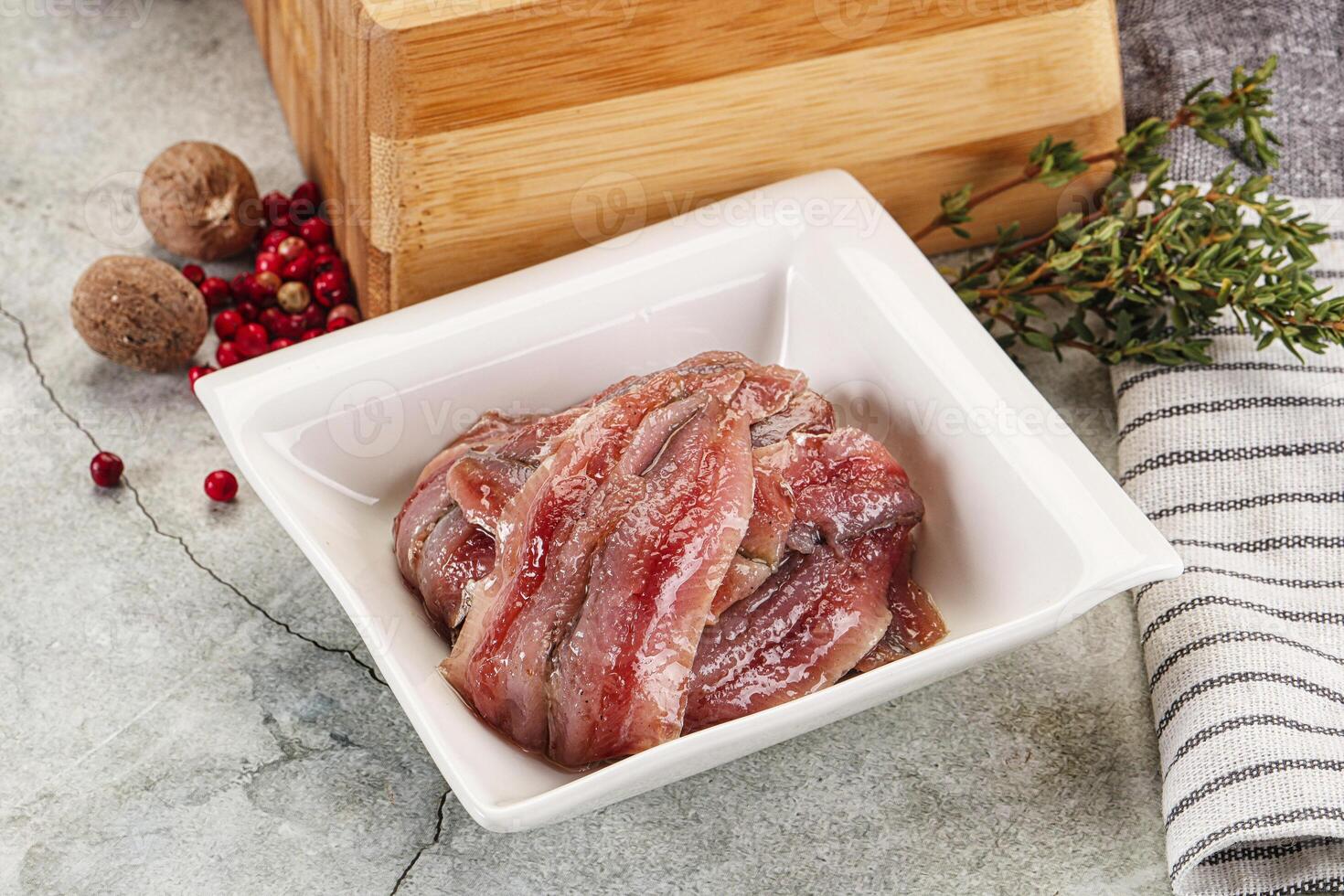 A bowl of meat sitting on a counter next to a wooden box photo