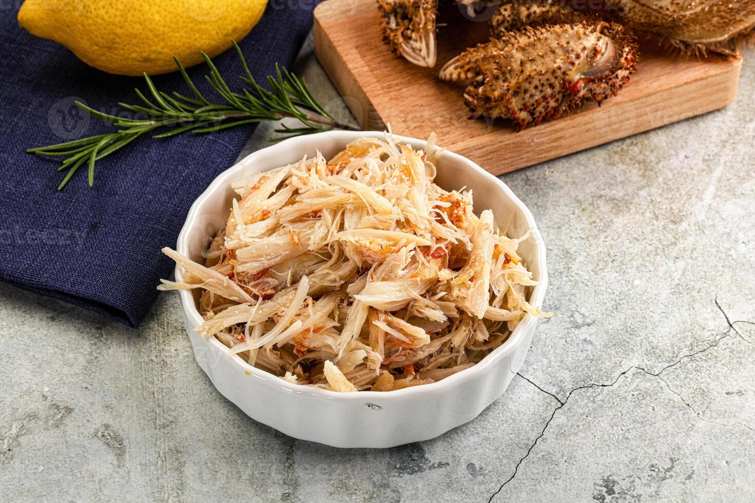 A bowl of food with a lemon and a knife photo