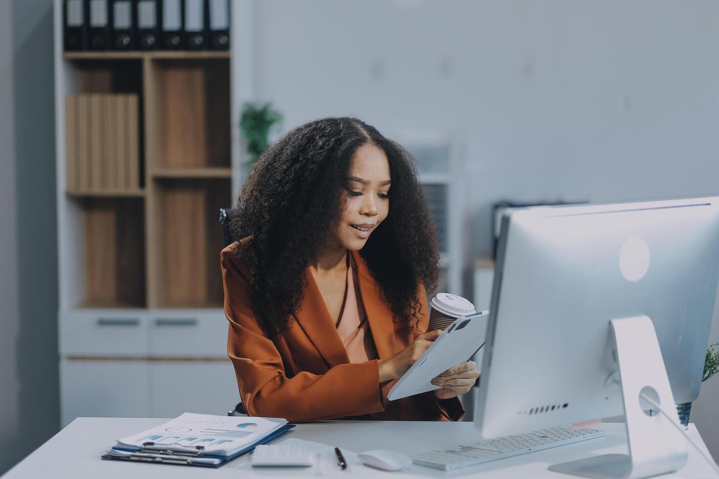 A woman in an office setting using a computer photo