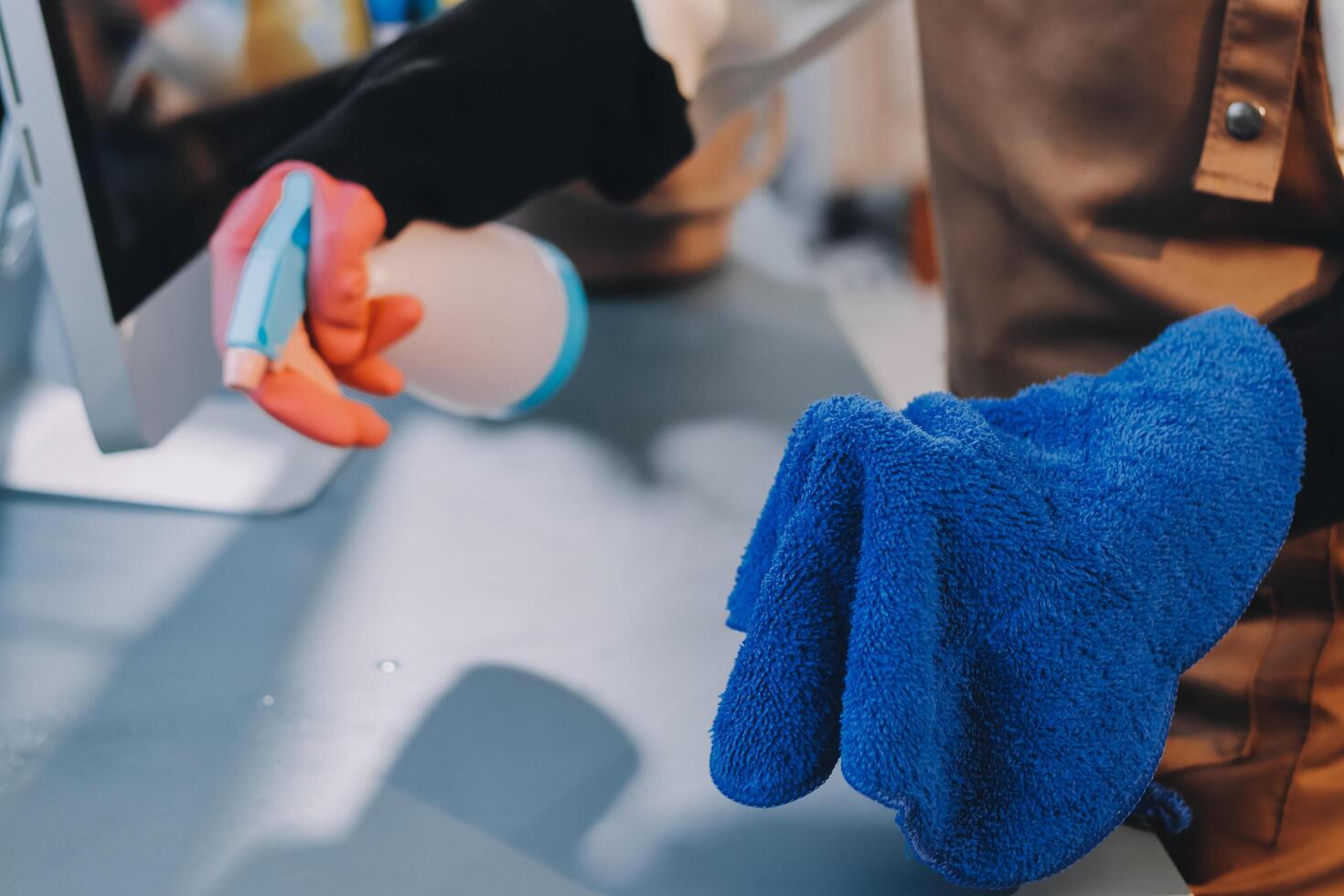 A person is cleaning a computer with a blue glove photo