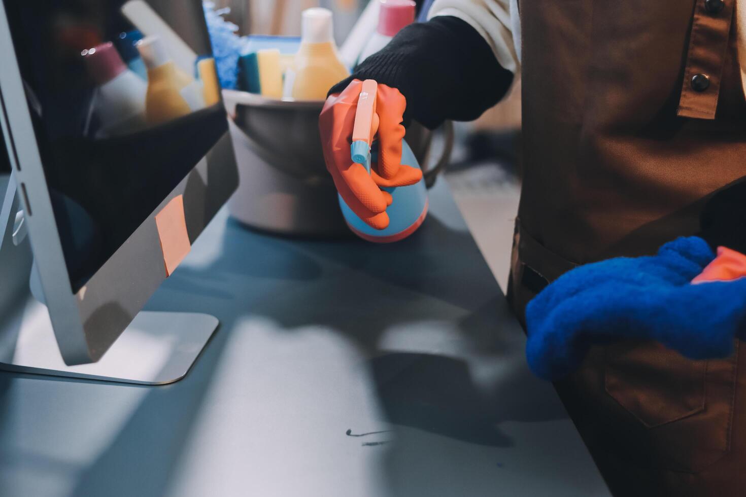A person wearing gloves and rubber gloves is cleaning a computer photo