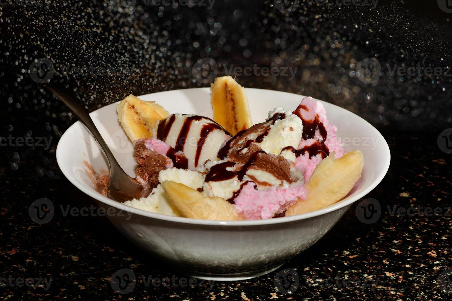 Delicious Banana Split Sundae with Chocolate Syrup photo
