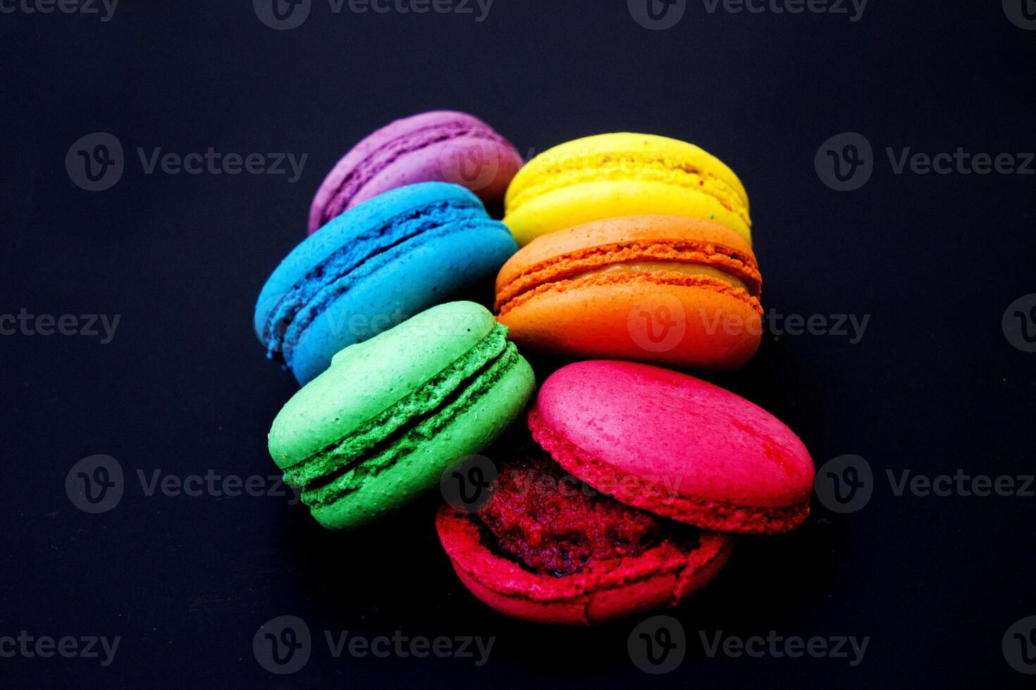 Sweet and colorful french macaroons or macaron on black background. photo