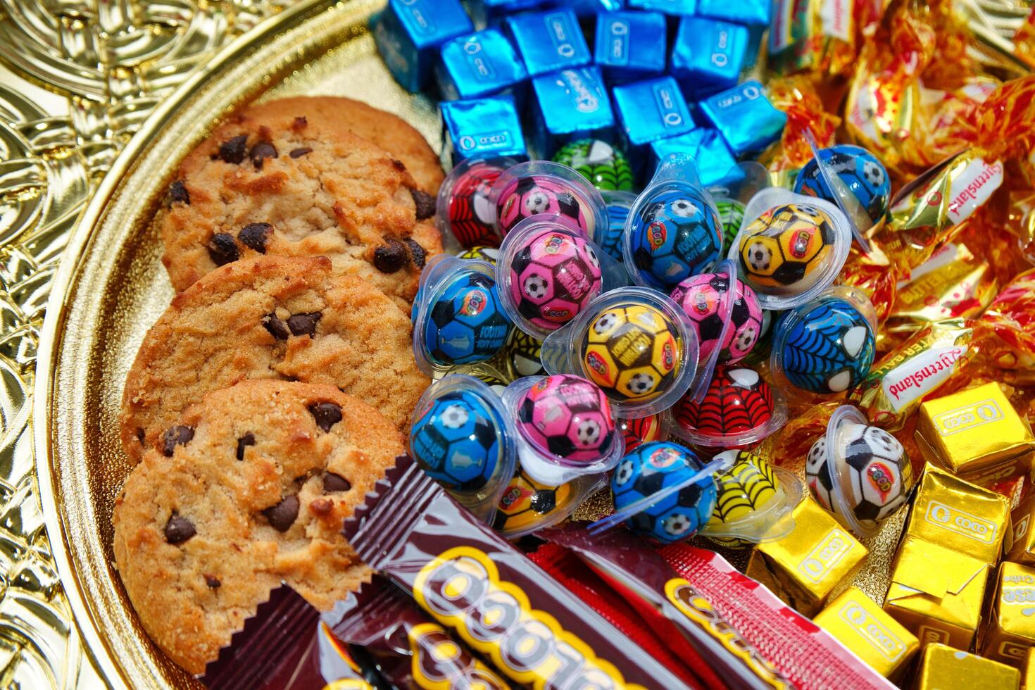 a gold plated tray with assorted candies and chocolates photo