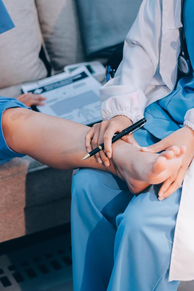 A doctor is holding a pen to a patient's foot photo