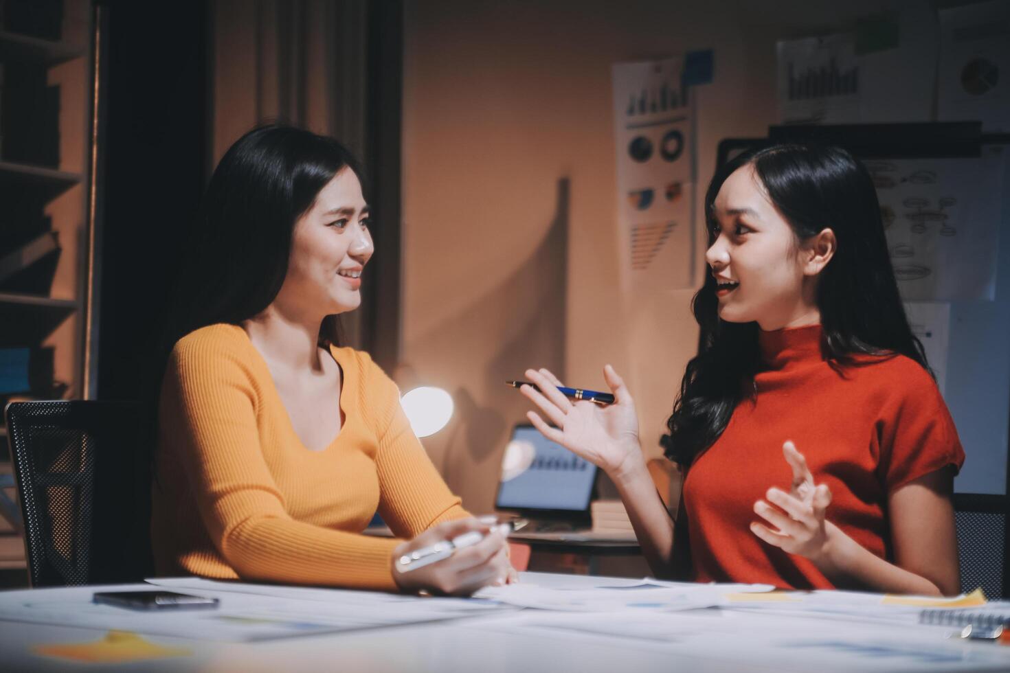 Two women talking at a table in an office photo