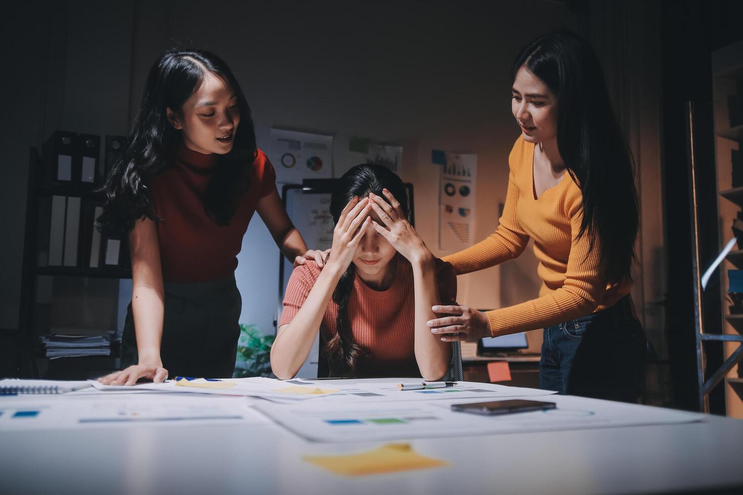 Three women are standing around a table with a man in the middle photo