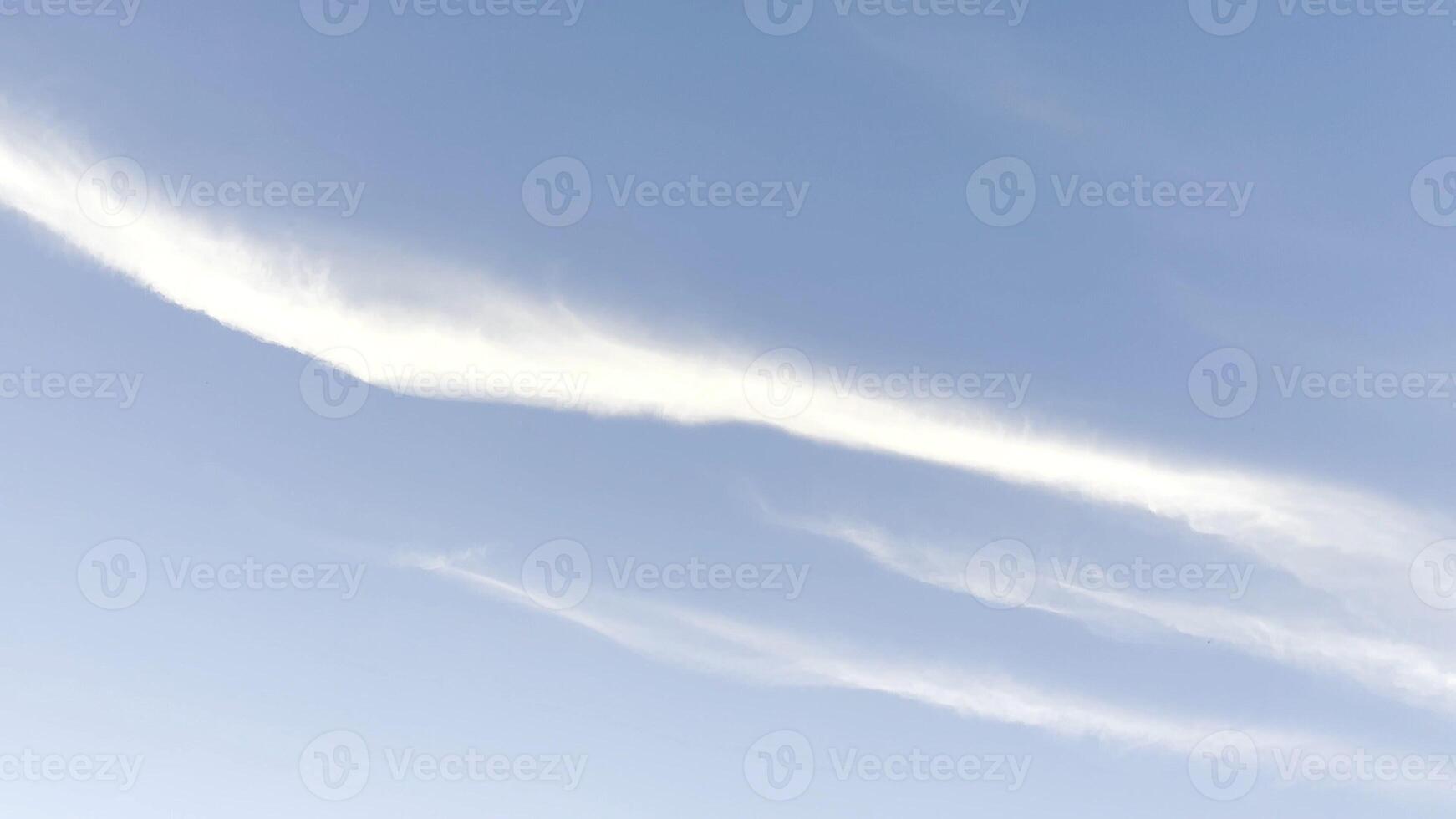 White lines after flying airplane in blue sky at summer sunny day. Beautiful cloudscape at background. Close up Slow motion photo