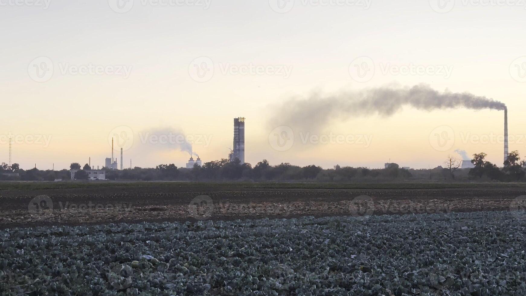 Heavy gray smoke is poured from the chimney pipes of thermal power plant. Carbon dioxide emitting from chimneys from industrial factory into the atmosphere. Concept of environmental pollution problem photo