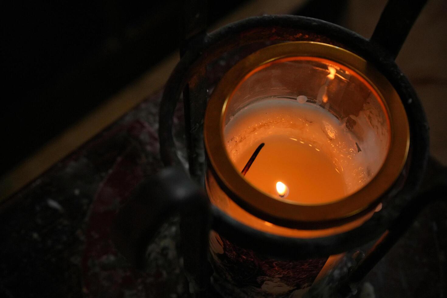 a candle is lit in a small metal lantern photo